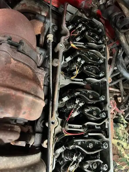 An engine with the rocker cover off showing the old gasket surface and rocker arms.